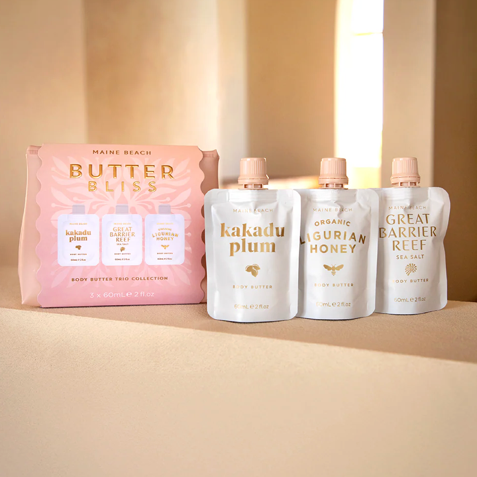 Butter Bliss body butter trio collection with packaging on a beige background