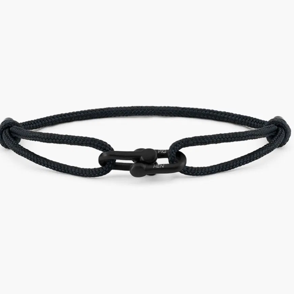 Black rope bracelet with a metal clasp on a white background