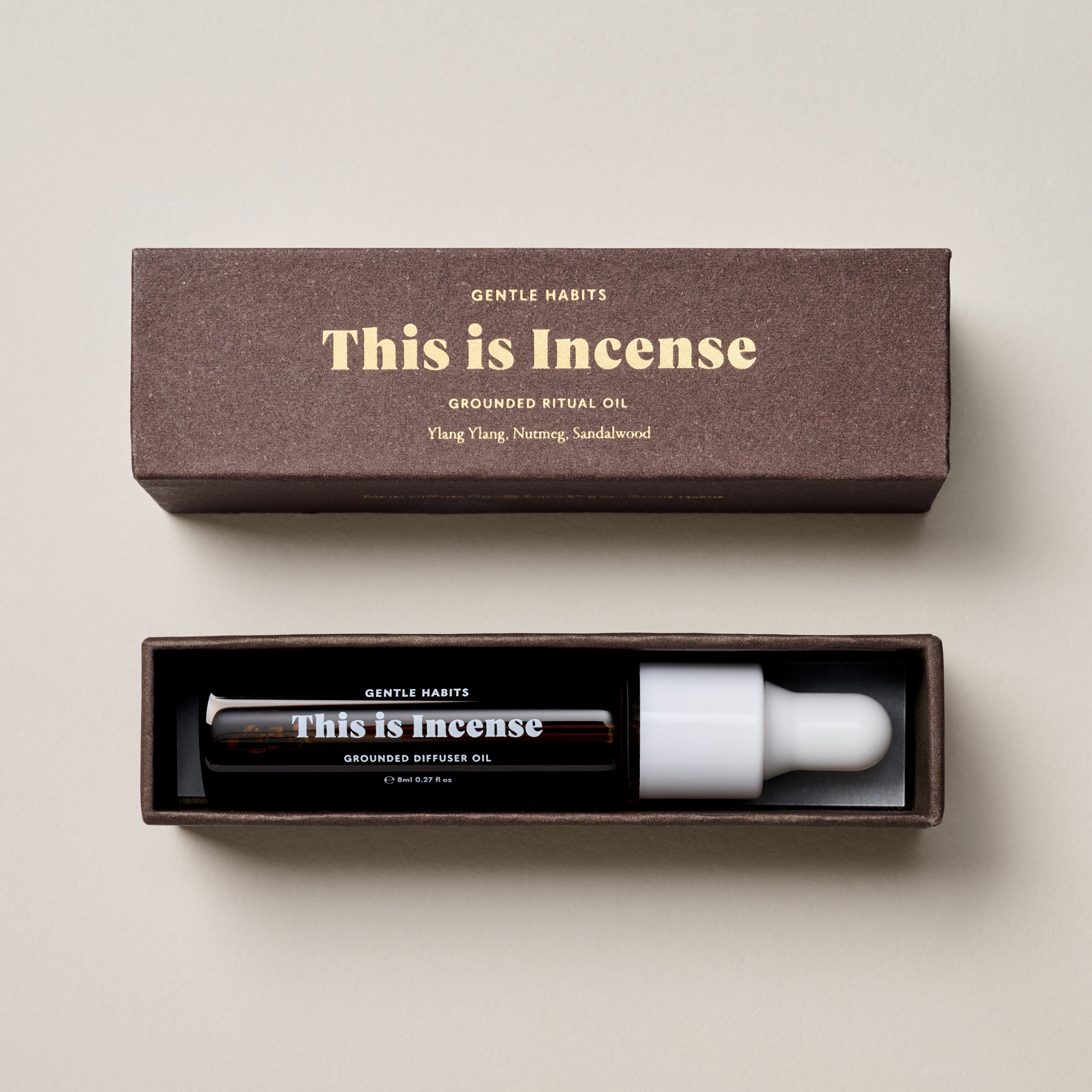 Grounded ritual oil with packaging on a beige background