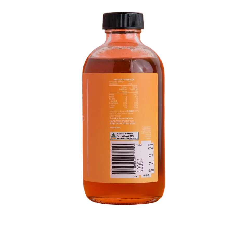 Bottle of syrup with a label on an orange background