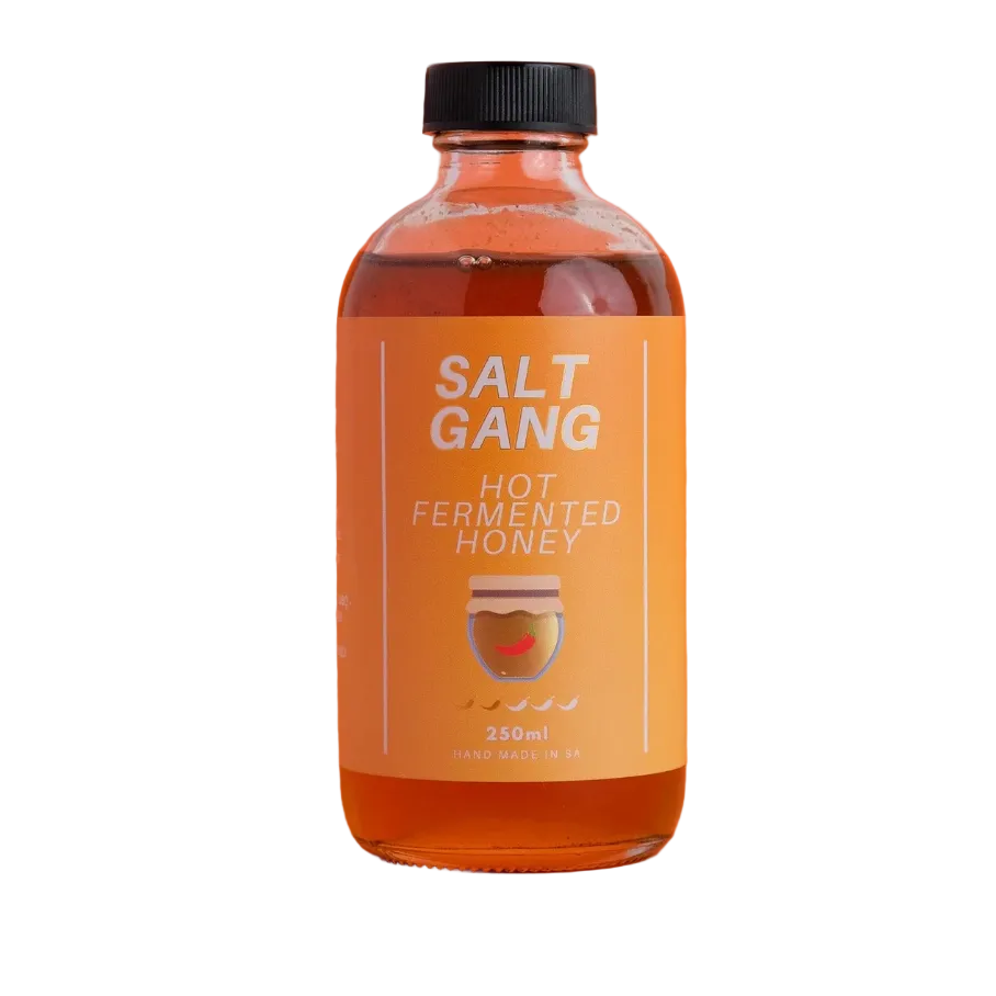 Bottle of Salt Gang hot fermented honey on an orange background