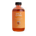 Bottle of Salt Gang hot fermented honey on an orange background