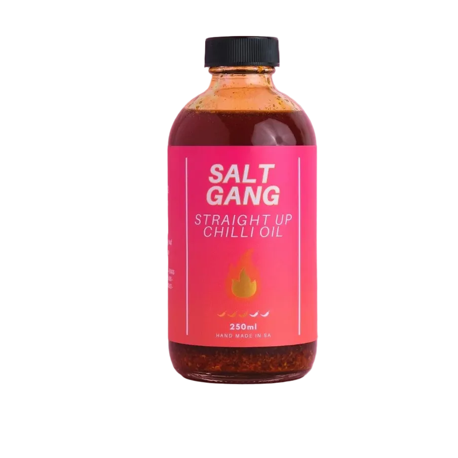 Bottle of Salt Gang Straight Up Chilli Oil on a pink background