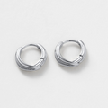 Pair of silver hoop earrings on a light gray background