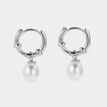 Silver hoop earrings with pearl drops on a white background