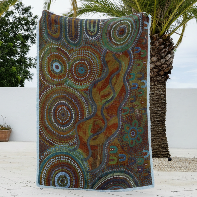 Decorative blanket with Aboriginal art design draped over a palm tree