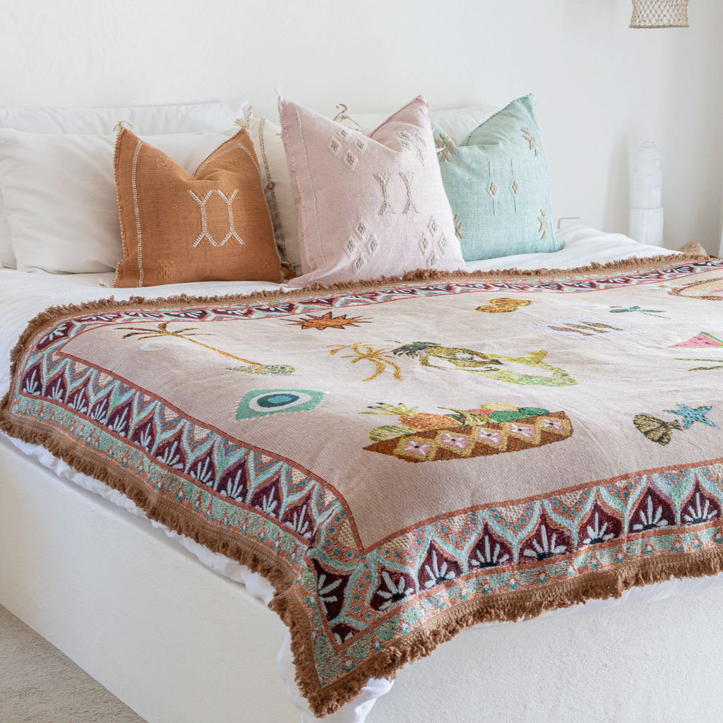 Bed with decorative quilt featuring animal prints and colorful pillows in a bedroom setting.