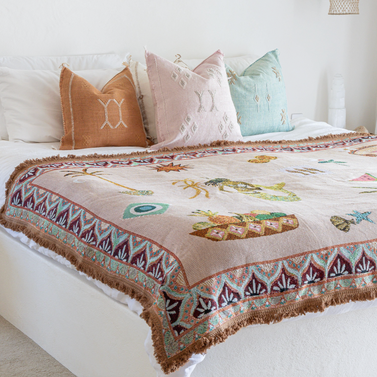 Bed with decorative quilt featuring animal prints and colorful pillows in a bedroom setting.
