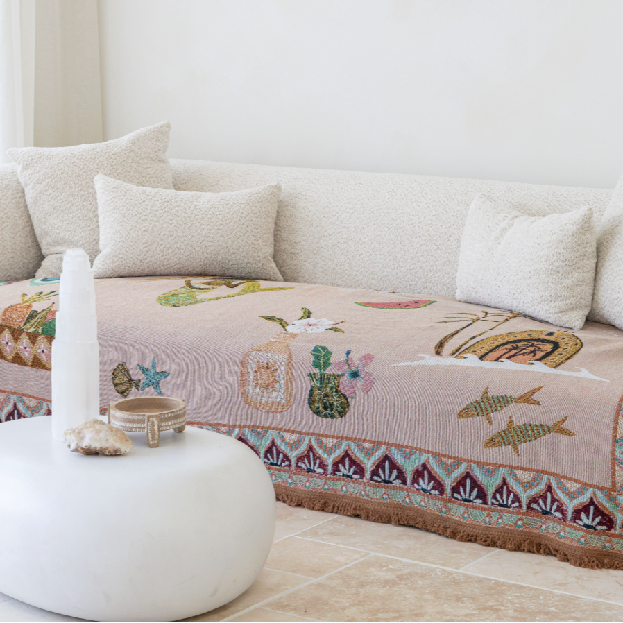 Decorative sofa with a patterned cover in a room with a mirror on the wall.