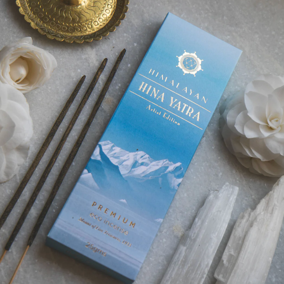 Himalayan incense packaging with incense sticks and decorative items on a gray surface